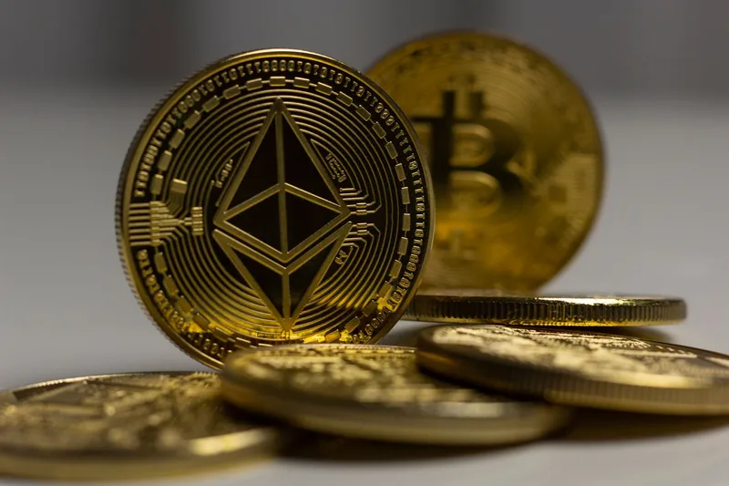 Physical Bitcoin and Ethereum gold coins close-up