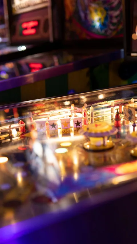 Vintage pinball playfield showing Plinko-style pegs and lights