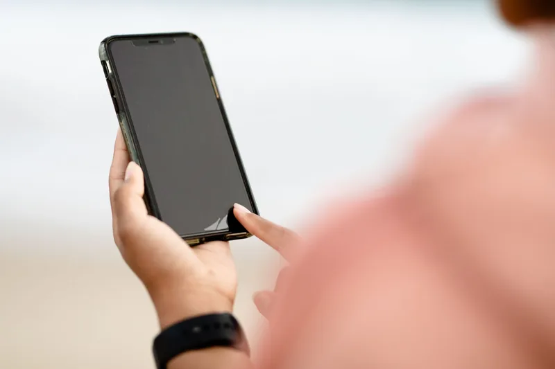 Person holding modern smartphone outdoors