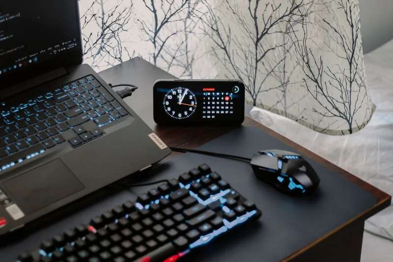 Laptop with backlit gaming keyboard and mouse on a desk