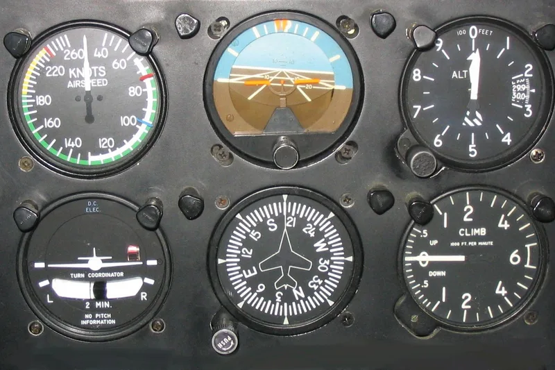 Analogue flight instruments on a black panel: airspeed indicator, artificial horizon, altimeter, turn coordinator, heading indicator and climb indicator