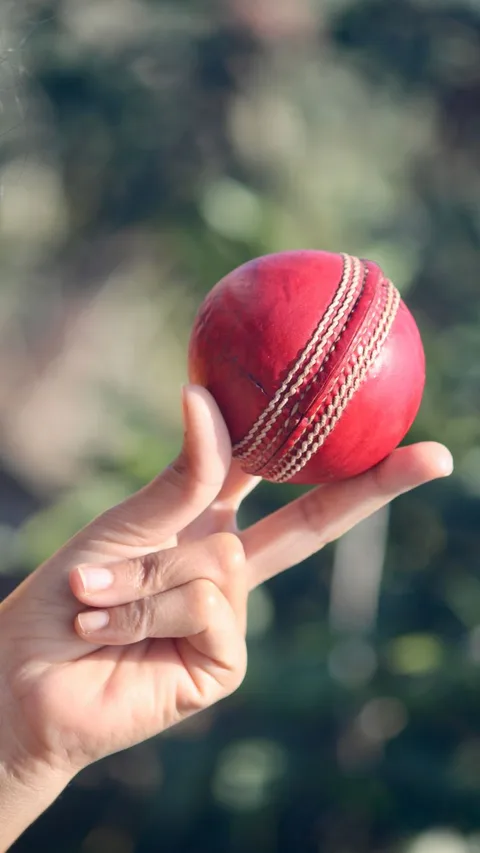 Hand dropping bright red ball