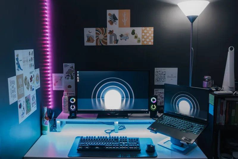 Stylish gaming setup featuring dual monitors, LED lighting, and tech accessories for an immersive experience.