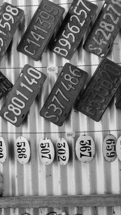Vintage metal number plates with embossed high numbers hanging on wall